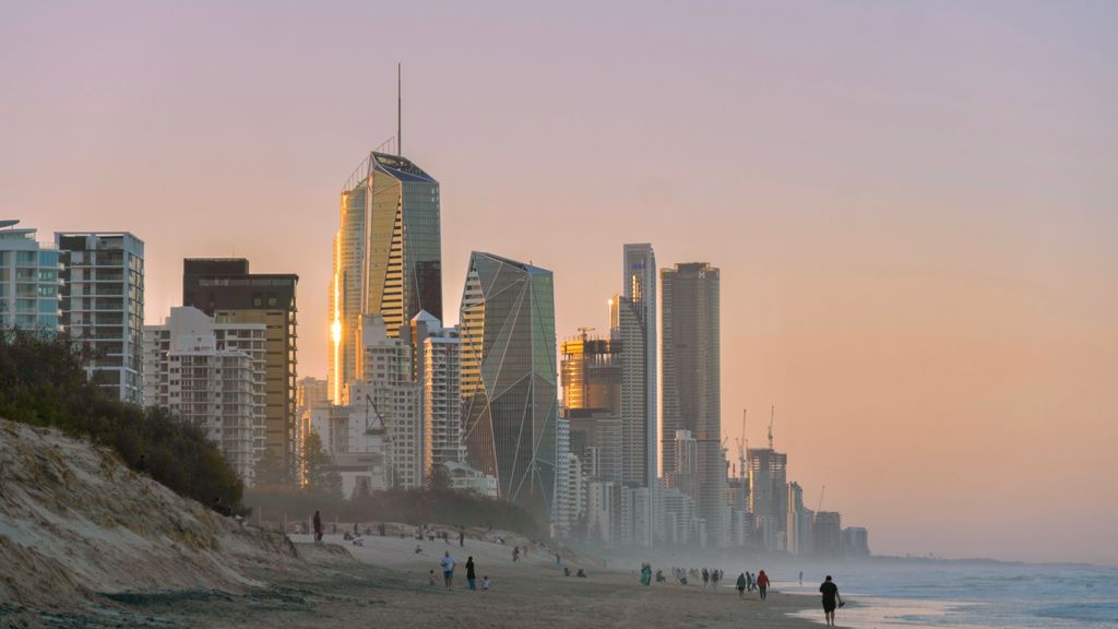 Beautiful sunset view of Surfers Paradise skyline, Gold Coast, Australia, with beachfront and people.