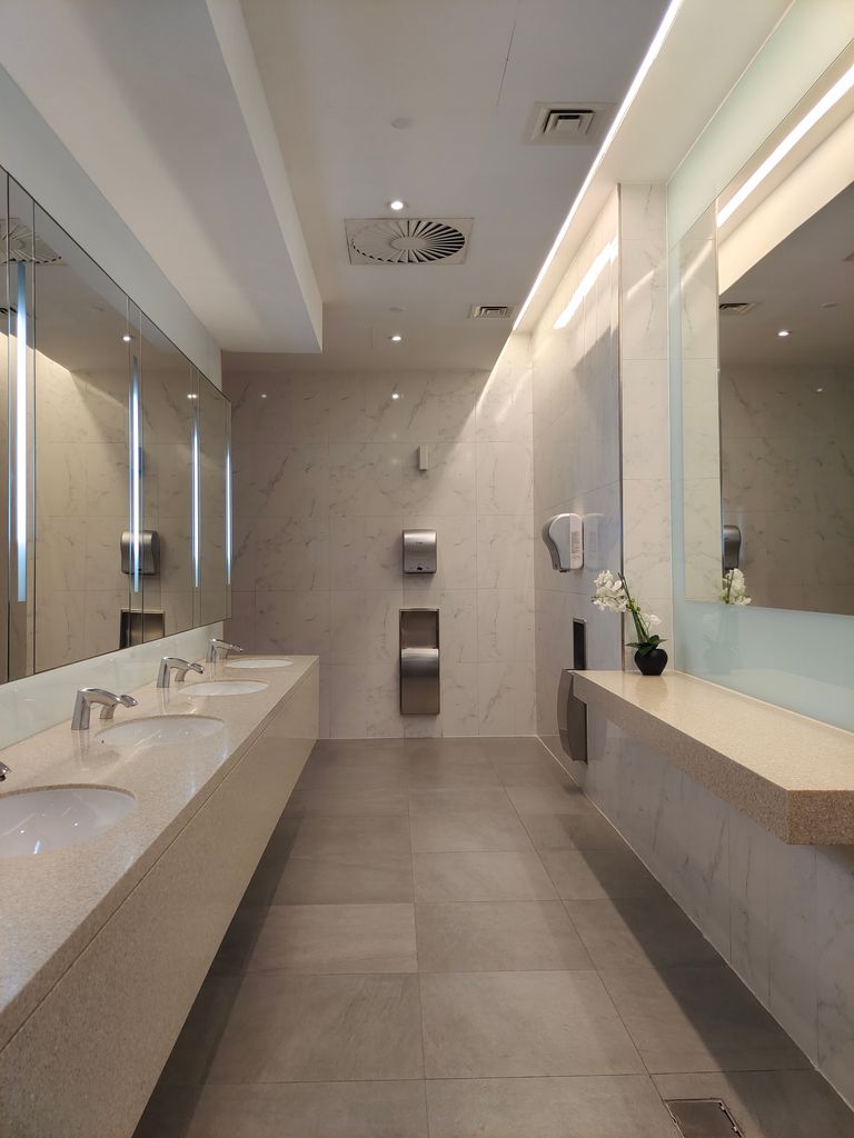 Spacious and elegant modern restroom with marble countertops and sleek design features.